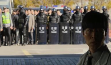 경찰 행렬 앞에 서 있는 인물