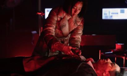 붉은 조명 속 응급 처치 장면